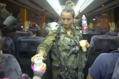 Một binh sỹ Israel đưa nước cho thành viên tổ chức Mũ bảo hiểm Trắng. (Nguồn: Reuters)