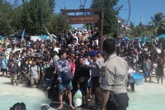 Hàng trăm khách du lịch chờ sơ tán khỏi Gili Trawangan, khu vực lân cận đảo Lombok, Indonesia, ngày 6/8. (Ảnh: AFP/TTXVN)