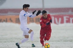 Pha tranh bóng giữa Jasurbek Yakhshiboev (trái) của U23 Uzbekistan với Vũ Văn Thanh (phải) của U23 Việt Nam trong trận đấu. (Nguồn: AFP/TTXVN)