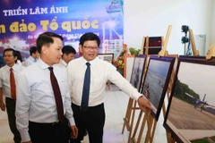 Ủy viên Trung ương Đảng, Tổng Giám đốc Thông tấn xã Việt Nam Nguyễn Đức Lợi và Phó Bí thư thường trực Thành ủy Đà Nẵng Võ Công Trí tham quan Triển lãm ảnh “Biển đảo Tổ quốc”. (Ảnh: Trần Lê Lâm/TTXVN)