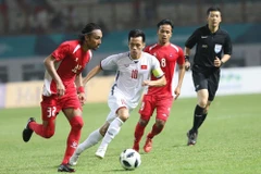 Pha tranh bóng của cầu thủ Olympic Việt Nam (áo trắng) và Olympic Nepal. (Ảnh: Hoàng Linh/TTXVN)