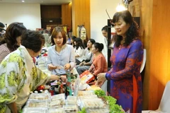 Khách hàng đang lựa chọn các sản phẩm tại gian hàng của Đại sứ quán Việt Nam. (Ảnh: Hải Ngọc/Vietnam+)