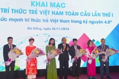 Phó Thủ tướng Thường trực Chính phủ Trương Hòa Bình tặng hoa cho các trí thức trẻ. (Ảnh: Đinh Văn Nhiều/TTXVN)