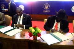 Tổng thống Nam Sudan Salva Kiir (phải) và thủ lĩnh phe đối lập Riek Machar (trái) tại lễ ký thỏa thuận chia sẻ quyền lực ở Khartoum ngày 5/8. (Ảnh: THX/TTXVN)
