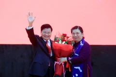 Phó Chủ tịch Thường trực Quốc hội Tòng Thị Phóng tặng hoa cho Thủ tướng Thongloun Sisoulith. (Ảnh: Phạm Kiên/TTXVN)