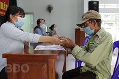 Ông Đặng Kim Trung, hành nghề xích lô (ở khu phố 1, phường Lê Lợi, thành phố Quy Nhơn) nhận tiền hỗ trợ dành cho lao động tự do. (Nguồn: https://binhdinh.dcs.vn)