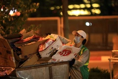 Công nhân Nguyễn Thanh Hoa, Công ty TNHH Một thành viên Môi trường đô thị Hà Nội (Urenco) đang thu dọn tại ngã tư Đường Láng-Trường Chinh. (Ảnh: Tuấn Anh/TTXVN)
