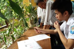 Thí sinh làm hồ sơ xét tuyển đại học. (Ảnh: Phạm Mai/Vietnam+)