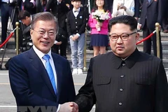 Tổng thống Hàn Quốc Moon Jae-in (trái) bắt tay hữu nghị Nhà lãnh đạo Triều Tiên Kim Jong-un (phải) tại làng đình chiến Panmunjom. (Nguồn: YONHAP/TTXVN) 