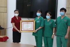 Phó Bí thư Thường trực tỉnh ủy Bắc Giang Lê Thị Thu Hồng trao Bằng khen của Thủ tướng chính phủ cho tập thể Bệnh viện Việt Nam-Thụy Điển Uông Bí (Quảng Ninh). (Ảnh: Danh Lam/TTXVN) 