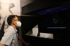 Khách tham quan mô hình ứng dụng công nghệ Hologram (một sản phẩm của kỹ thuật ghi hình 3D) tại Bảo tàng phụ nữ Nam Bộ. (Ảnh: Thu Hương/TTXVN)