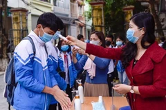 Đo thân nhiệt tại trường THCS Lý Tự Trọng, thành phố Thanh Hóa. (Ảnh: Khiếu Tư/TTXVN)