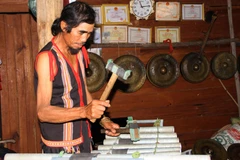 Ông A Thui biểu diễn chiếc đàn T’rưng sắt do chính ông chế tác. (Ảnh: Khoa Chương/TTXVN)