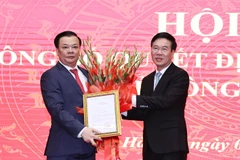 Ông Võ Văn Thưởng, Ủy viên Bộ Chính trị, Thường trực Ban Bí thư trao Quyết định của Bộ Chính trị phân công ông Đinh Tiến Dũng giữ chức Bí thư Thành ủy Hà Nội. (Ảnh: Văn Điệp/TTXVN)