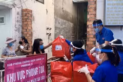 Đoàn viên thanh niên Thành phố Hồ Chí Minh cung cấp nhu yếu phẩm cho những hộ dân thuộc khu vực phong toả tại phường 3, Quận 11. (Ảnh: Hồng Giang/TTXVN) 