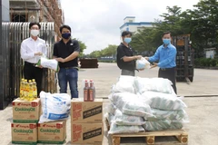 Ông Nguyễn Châu Trinh, Phó Chủ tịch Liên đoàn Lao động tỉnh cùng ông Nguyễn Trường Giang, Phó Bí thư Đảng ủy khối Cơ quan và Doanh nghiệp tỉnh Bà Rịa-Vũng Tàu trao những phần quà là nhu yếu phẩm thiết yếu cho công nhân đang hoạt động theo mô hình 3 tại ch