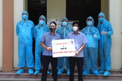 Tình nguyện viên của Chương trình Ranh Giới và bạn bè phối hợp VNews (Truyền hình TTXVN) trao quà hỗ trợ cho Mặt trận Tổ quốc huyện Việt Yên (Bắc Giang). (Ảnh: Danh Lam/TTXVN)