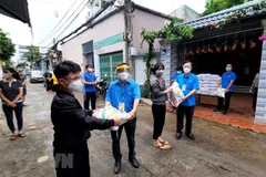 Đại diện Liên đoàn Lao động quận thành phố Thủ Đức trao quà cho công nhân ở trọ. (Ảnh: Thanh Vũ/TTXVN) 