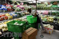 Nhân viên sắp xếp thực phẩm trong siêu thị tại Bắc Kinh, Trung Quốc ngày 17/6/2020. (Ảnh: AFP/TTXVN) 