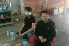 Hai đối tượng nước ngoài bị lực lượng chức năng bắt giữ. (Ảnh: TTXVN phát)