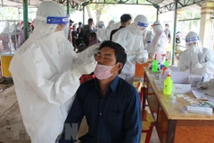 Lực lượng y tế xét nghiệm cho người dân để đưa đi cách ly tập trung hoặc cho cách ly tại nhà nếu người dân đã tiêm 2 mũi vaccine. (Ảnh: Hoài Thu/TTXVN) 