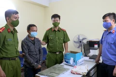 Đối tượng Giàng Bả Dế và tang vật tại cơ quan công an. (Ảnh: TTXVN phát) 