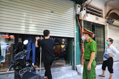 Các chủ cơ sở kinh doanh dịch vụ không thiết yếu trên phố Nguyễn Lương Bằng đều chấp hành đóng cửa để phòng chống dịch. (Ảnh: Thành Đạt/TTXVN) 
