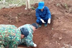 Đội Quy tập hài cốt liệt sỹ của Đoàn Kinh tế-Quốc phòng 337 cất bốc hài cốt liệt sỹ tại bản Cheng, xã Tân Liên, huyện Hướng Hóa, tỉnh Quảng Trị. (Ảnh: TTXVN phát)