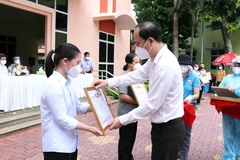 Phó Bí thư Thành ủy Thành phố Hồ Chí Minh Nguyễn Hồ Hải trao giấy biểu dương tri ân các tình nguyện viên tôn giáo đã hoàn thành nhiệm vụ. (Ảnh: Xuân Khu/TTXVN) 