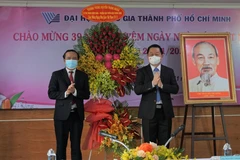 Bí thư Trung ương Đảng, Trưởng ban Tuyên giáo Trung ương Nguyễn Trọng Nghĩa tặng hoa chúc mừng thầy cô giáo Đại học Quốc gia Thành phố Hồ Chí Minh. (Ảnh: Thu Hoài/TTXVN)