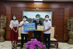 Bí thư Tỉnh ủy Hải Dương Phạm Xuân Thăng (ngoài cùng, bên phải) và Chủ tịch Ủy ban Mặt trận Tổ quốc Việt Nam tỉnh Hải Dương Nguyễn Đức Tuấn (thứ 2, từ trái sang) tiếp nhận ủng hộ của Công ty trách nhiệm hữu hạn Công nghiệp Brother. (Ảnh: Mạnh Minh/TTXVN)