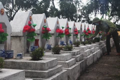 Ông Chính thắp hương cho các phần mộ tại Nghĩa trang Liệt sỹ Hàm Rồng. (Ảnh: Khiếu Tư/TTXVN) 