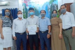 Lãnh đạo Sở Giáo dục và Đào tạo Hải Phòng chúc mừng Trần Cao Sơn đạt kết quả xuất sắc trong kỳ thi tốt nghiệp Trung học phổ thông 2021. (Ảnh: TTXVN phát)