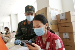 Cán bộ, chiến sỹ hỗ trợ các em học trực tuyến tại lớp học dã chiến ở chung cư 1050 (quận Bình Thạnh). (Ảnh: Thu Hương/TTXVN)