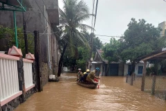 Nhân viên EVNCPC chèo thuyền đi kiểm tra hệ thống điện tại các nơi ngập nước để nhanh chóng khôi phục các sự cố về điện tại các vùng ngập lũ. (Ảnh: TTXVN phát)