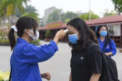 Các thí sinh ở Thanh Hóa đều được đo thân nhiệt trước khi vào khu vực thi. (Ảnh: Khiếu Tư/TTXVN)