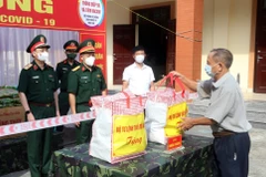 Thiếu tướng Nguyễn Quốc Duyệt, Tư lệnh Bộ Tư lệnh Thủ đô Hà Nội trao quà cho người dân phường Trung Văn, quận Nam Từ Liêm. (Ảnh: Nguyễn Cúc/TTXVN)