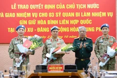 Thượng tướng Nguyễn Chí Vịnh, Thứ trưởng Bộ Quốc phòng trao Quyết định của Chủ tịch nước cho 3 sỹ quan thực hiện nhiệm vụ Gìn giữ hòa bình Liên hợp quốc tại Phái bộ Nam Sudan và Cộng hòa Trung Phi. (Ảnh: Dương Giang/TTXVN) 