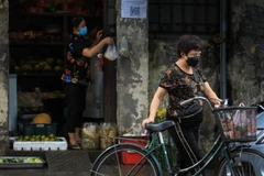 Nhịp sống trở lại, người dân đã thoải mái ra đường đi chợ. (Ảnh: Thành Đạt/TTXVN) 