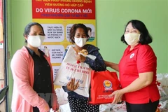 Trao quà cho người bán vé số dạo bị ảnh hưởng dịch bệnh COVID-19. Ảnh minh họa. (Ảnh: Thanh Vũ/TTXVN)