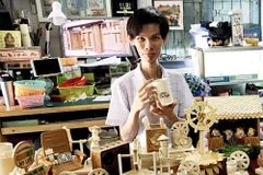 Anh Triệu Hồng Hồ Em cùng các sản phẩm thủ công từ tre. (Ảnh: Công Mạo/TTXVN) 