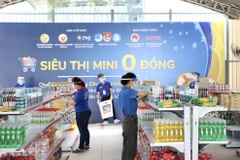 Đoàn viên thanh niên tình nguyện lựa chọn các loại hàng hoá 0 đồng theo đơn đặt hàng của các bạn sinh viên. (Ảnh: Hồng Giang/TTXVN)