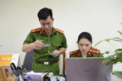 Trả căn cước công dân gắn chip điện tử cho người dân. (Ảnh: Xuân Tư/TTXVN)