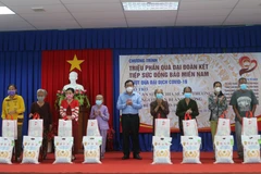 Ông Nguyễn Tiếc Hùng, Chủ tịch Ủy ban Mặt trận Tổ quốc Việt Nam tỉnh An Giang trao quà cho người dân gặp khó khăn do ảnh hưởng bởi dịch COVID-19 huyện Châu Thành. (Ảnh: Công Mạo/TTXVN)