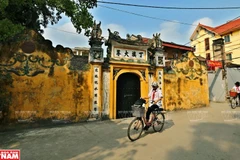 Xen kẽ giữa những ngôi nhà cao tầng, những bức tường sơn mới là sự trầm lắng của những bức tường cổ nhuốm màu rêu phong ở làng cổ Cự Đà. (Ảnh: Công Đạt/VNP)