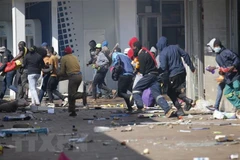 Các đối tượng cướp phá tại một cửa hàng ở Johannesburg, Nam Phi ngày 12/7/2021. (Ảnh: AFP/TTXVN) 