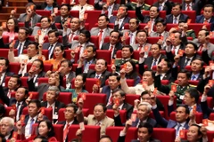 Các đại biểu biểu quyết, thông qua Nghị quyết Đại hội XIII Đảng Cộng sản Việt Nam. (Ảnh: TTXVN)