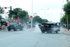 Tiểu đoàn Hóa học 38 phun thuốc khử trùng trên các tuyến đường thuộc phường Bình Chuẩn, thành phố Thuận An. (Ảnh: Văn Hướng-Tuấn Anh/TTXVN)