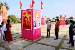 Người dân xem triển lãm tranh cổ động kỷ niệm 110 năm Ngày Bác Hồ ra đi tìm đường cứu nước tại khuôn viên Bảo tàng Hồ Chí Minh chi nhánh Bình Thuận. (Ảnh: Nguyễn Thanh/TTXVN)