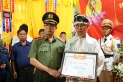 Trao Bằng Tổ quốc ghi công cho gia đình Thiếu tá Hoàng Trung, cán bộ Công an xã Ea Ktur, huyện Cư Kuin. (Ảnh: Quang Thái/TTXVN)